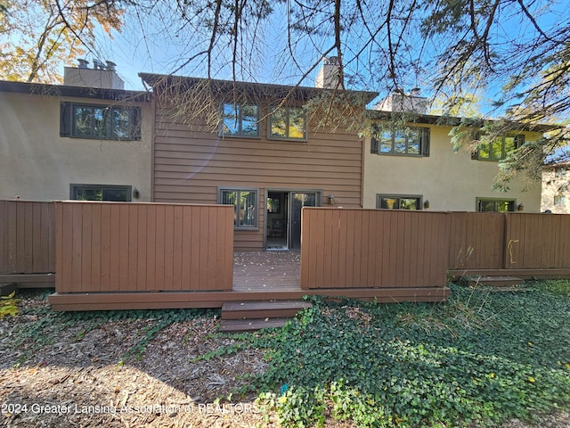 rear view of house featuring a wooden deck