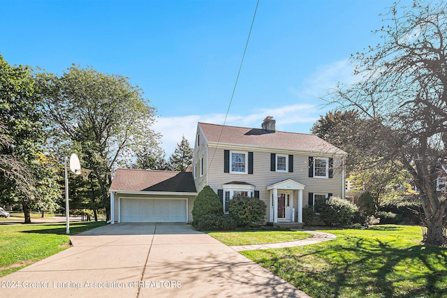 colonial home with a garage and a front lawn