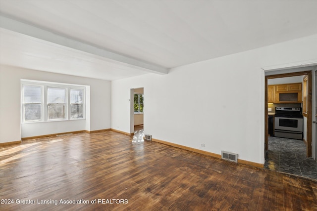 spare room featuring beamed ceiling and dark hardwood / wood-style floors