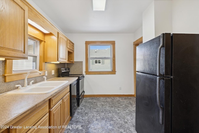 kitchen with light brown cabinets, black appliances, and sink