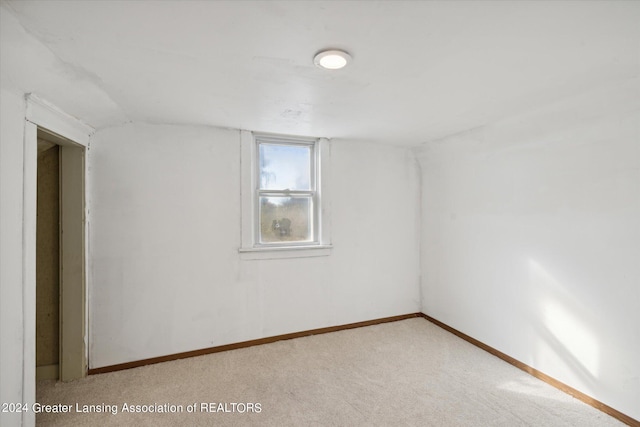 interior space featuring vaulted ceiling and light carpet