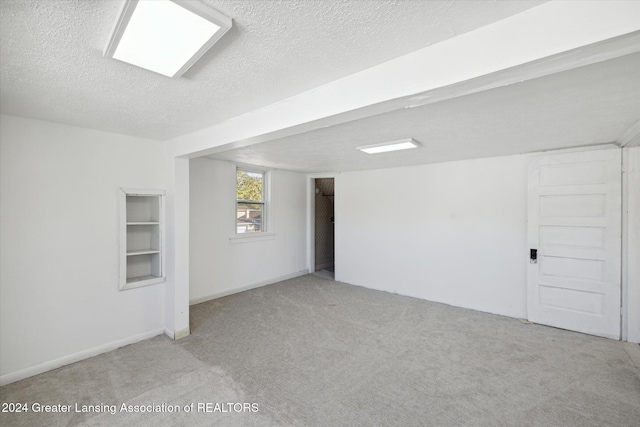 carpeted empty room featuring a textured ceiling