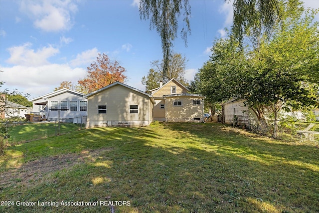 rear view of property featuring a lawn