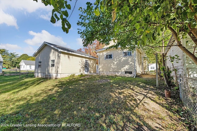 rear view of property featuring a lawn