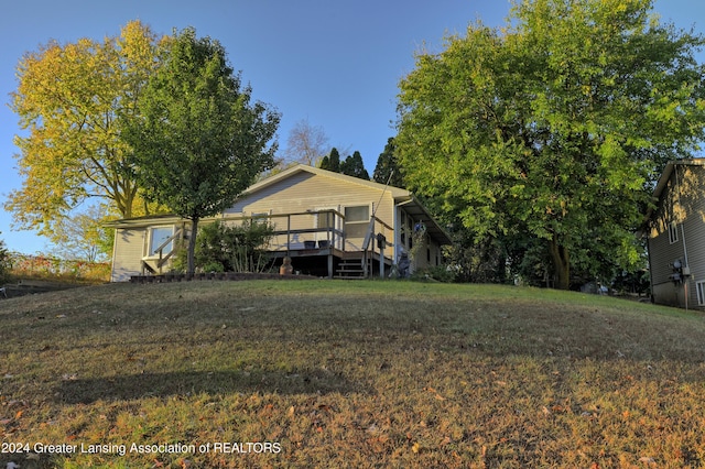 rear view of property with a yard and a wooden deck
