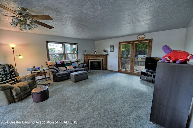 living area with plenty of natural light, carpet, a textured ceiling, and a ceiling fan