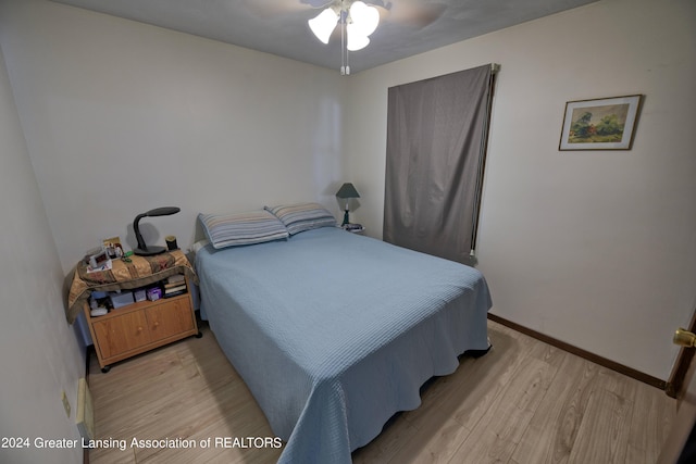 bedroom featuring light wood-style floors, baseboards, and a ceiling fan