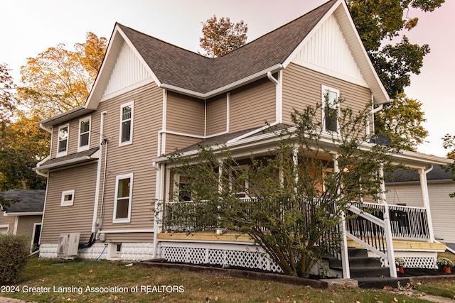 back house at dusk with a wooden deck