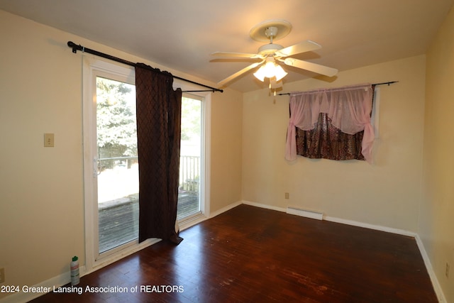 empty room featuring dark hardwood / wood-style flooring, baseboard heating, and ceiling fan