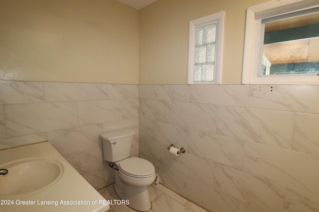 bathroom with tile walls, vanity, and toilet