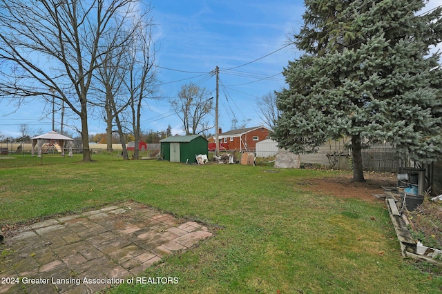 view of yard with a storage unit and a patio area