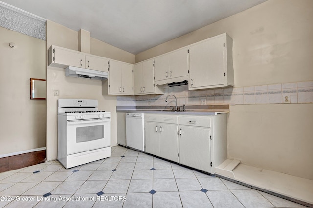 kitchen with backsplash, sink, vaulted ceiling, white cabinets, and white appliances