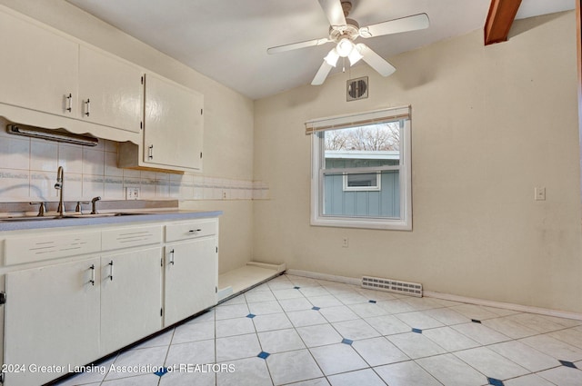 kitchen featuring white cabinetry, sink, tasteful backsplash, and light tile patterned flooring