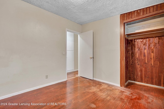 unfurnished bedroom featuring wood-type flooring and a textured ceiling