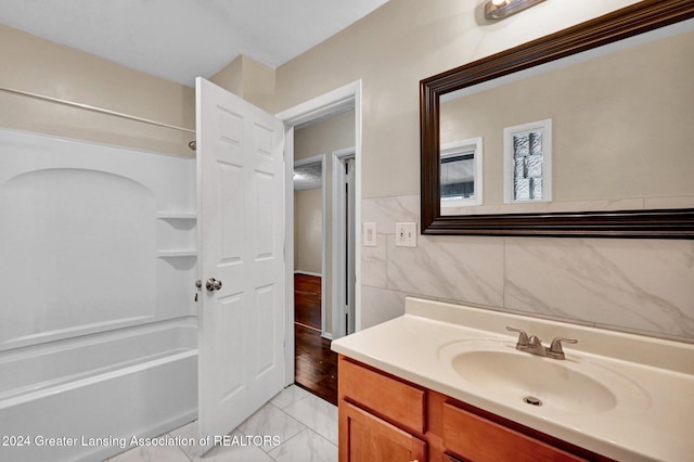 bathroom featuring vanity, tub / shower combination, tile walls, and tile patterned floors