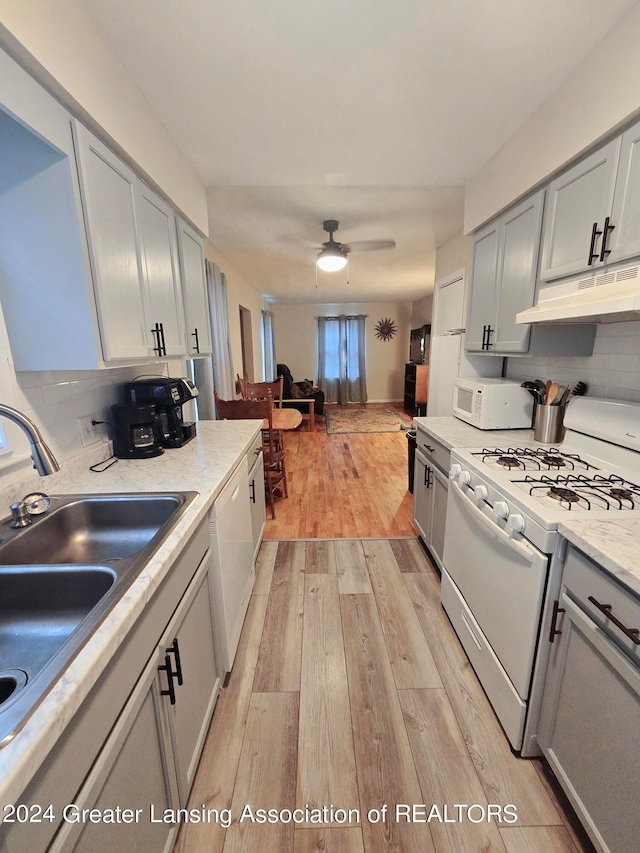 kitchen with light hardwood / wood-style floors, gray cabinetry, ceiling fan, white appliances, and decorative backsplash