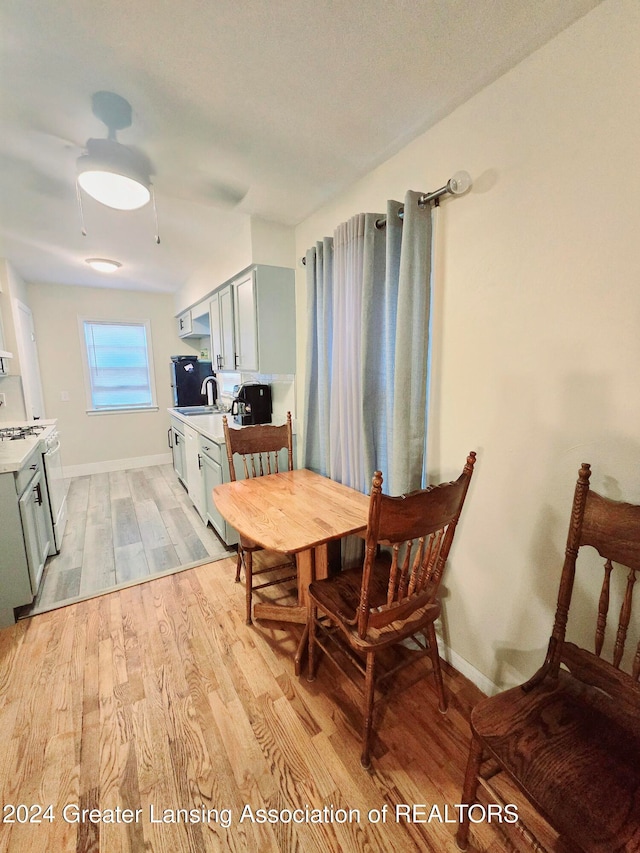 dining room featuring sink and light hardwood / wood-style flooring