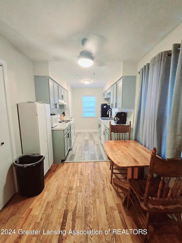 kitchen with white appliances, sink, and light wood-type flooring