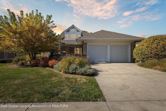 view of front of property with a garage and a lawn