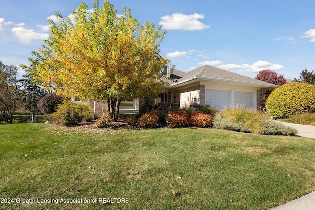 view of front of home with a front yard and a garage