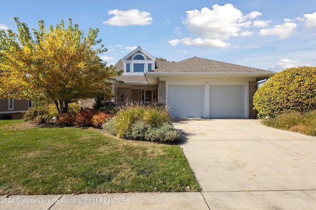 view of front of property featuring a front yard and a garage