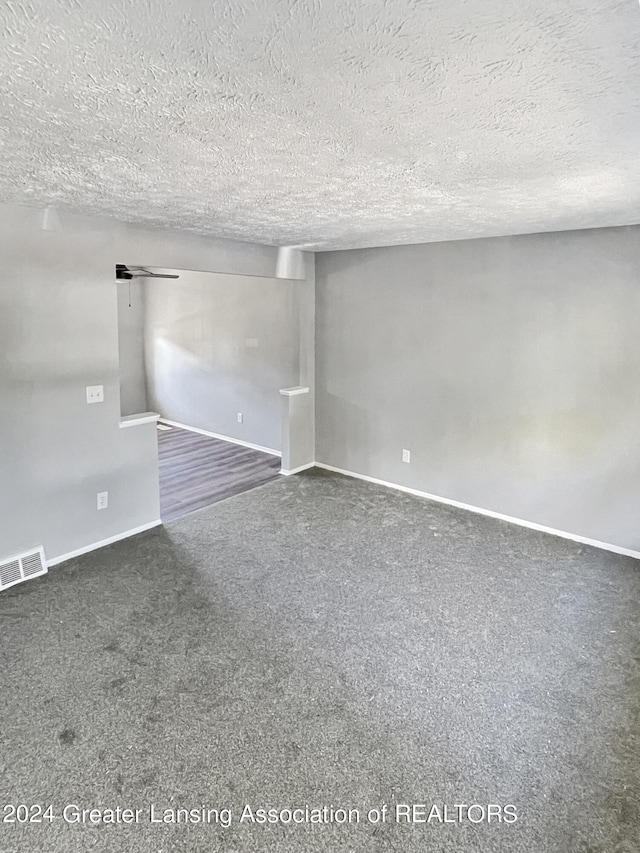 carpeted empty room featuring a textured ceiling