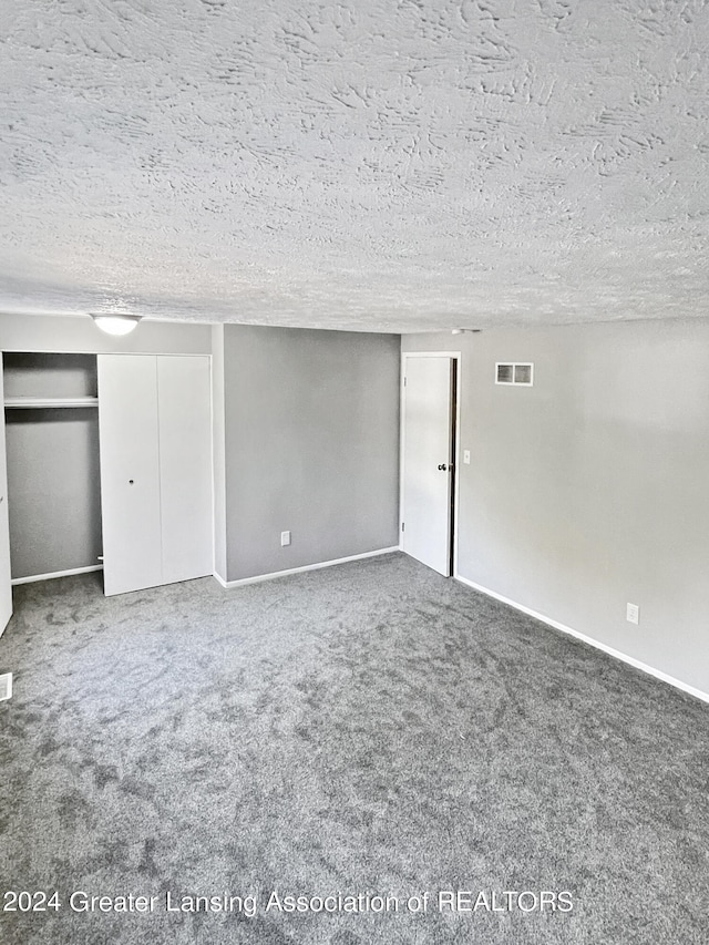 interior space featuring carpet flooring and a textured ceiling