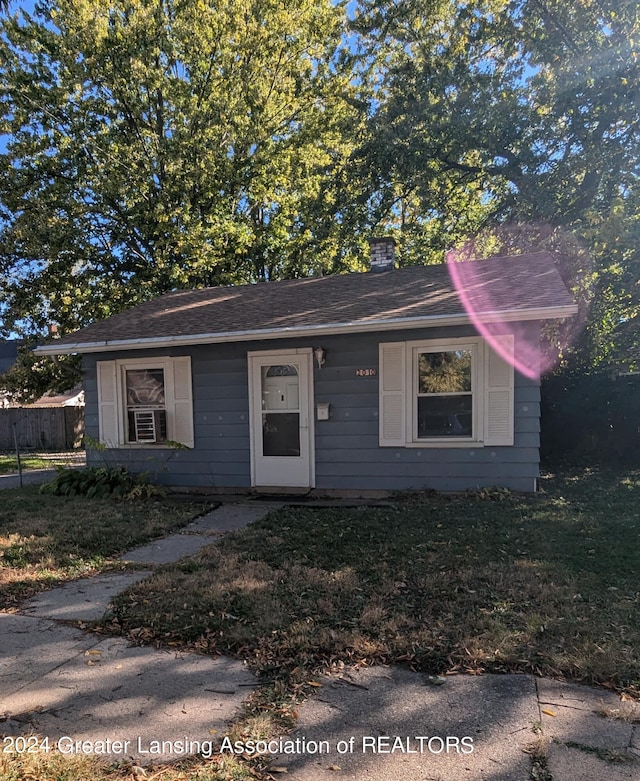 view of front of house with cooling unit and a front lawn