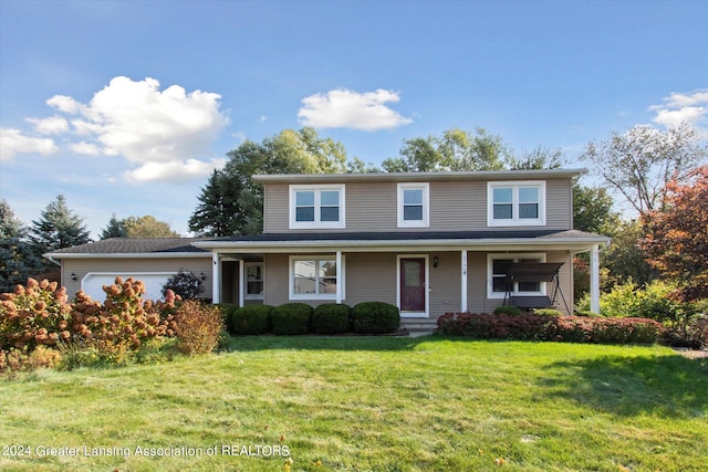 view of property featuring a garage, a porch, and a front lawn