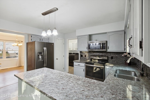 kitchen featuring gray cabinetry, light hardwood / wood-style flooring, decorative light fixtures, sink, and appliances with stainless steel finishes