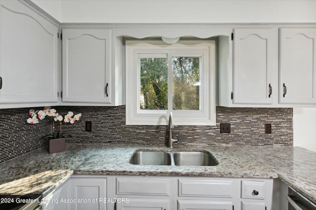 kitchen with backsplash, sink, and white cabinets