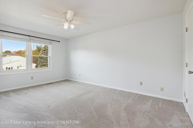 unfurnished room with light colored carpet and ceiling fan