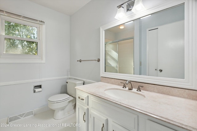 bathroom featuring tile patterned floors, vanity, walk in shower, and toilet