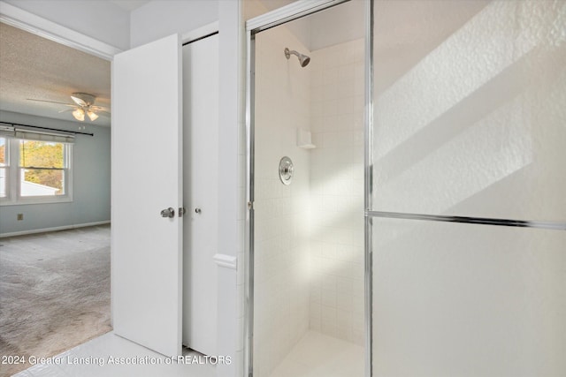 bathroom with an enclosed shower and ceiling fan