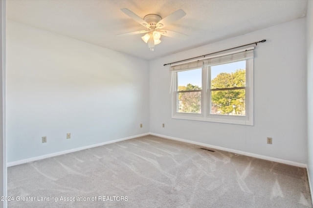 carpeted spare room with ceiling fan