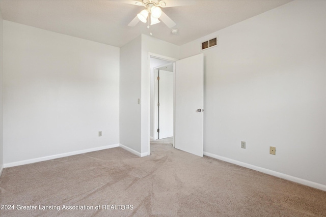 empty room with ceiling fan and light colored carpet