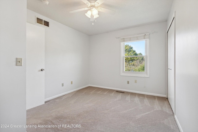 unfurnished room with ceiling fan and light colored carpet