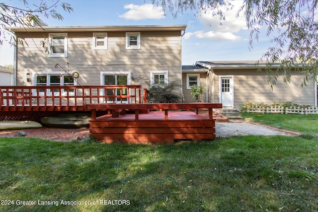 rear view of property featuring a deck and a lawn