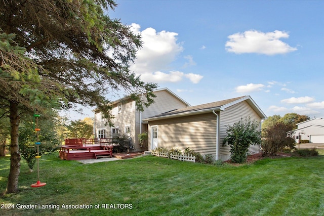 view of side of property with a deck and a lawn