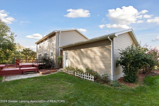 view of property exterior with a yard and a wooden deck