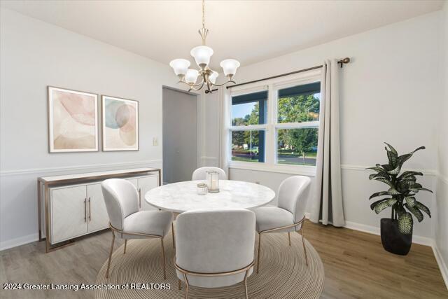 dining area featuring wood-type flooring and a chandelier