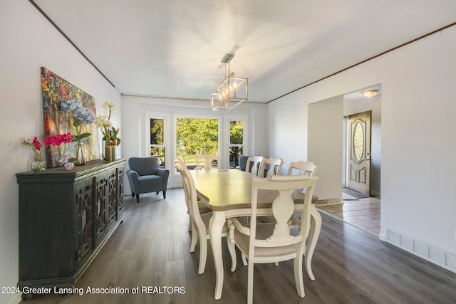 dining room with dark hardwood / wood-style floors and an inviting chandelier