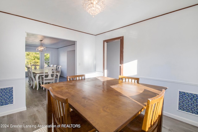 dining room featuring a notable chandelier, crown molding, and hardwood / wood-style floors