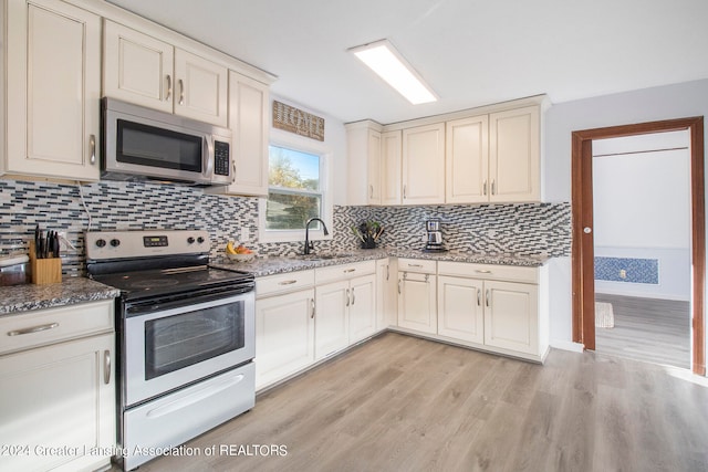 kitchen with light hardwood / wood-style floors, sink, decorative backsplash, light stone countertops, and electric stove