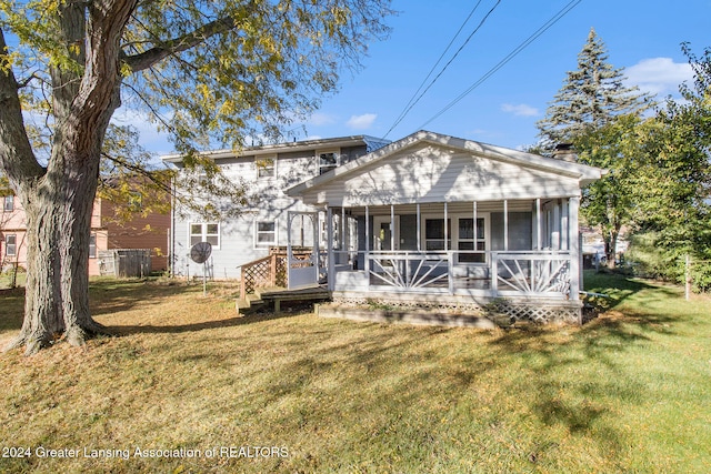 back of house featuring a sunroom and a lawn