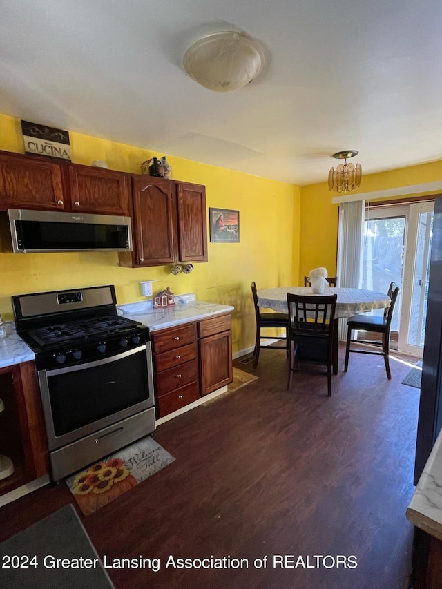 kitchen with a notable chandelier, stainless steel appliances, and dark hardwood / wood-style flooring