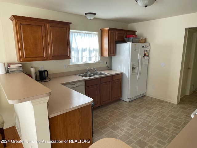 kitchen featuring white appliances, sink, and kitchen peninsula