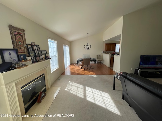 living room featuring lofted ceiling, a notable chandelier, and light hardwood / wood-style floors