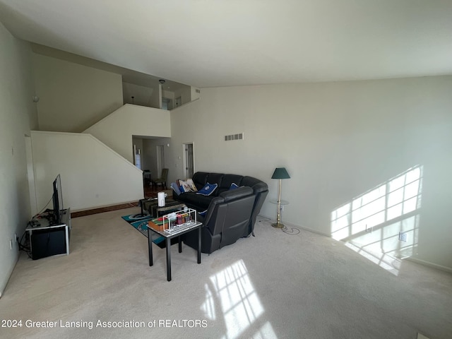 living room with light colored carpet and high vaulted ceiling