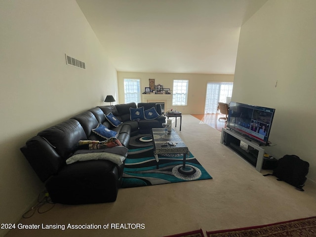 carpeted living room featuring vaulted ceiling